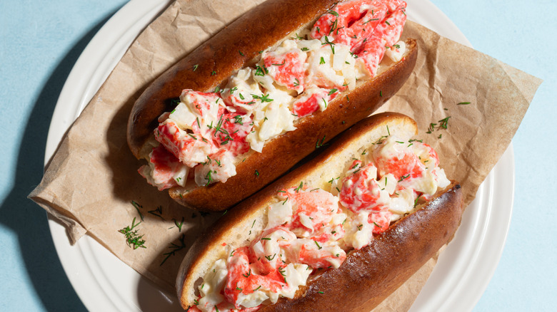 Two classic Maine lobster rolls on a paper plate.