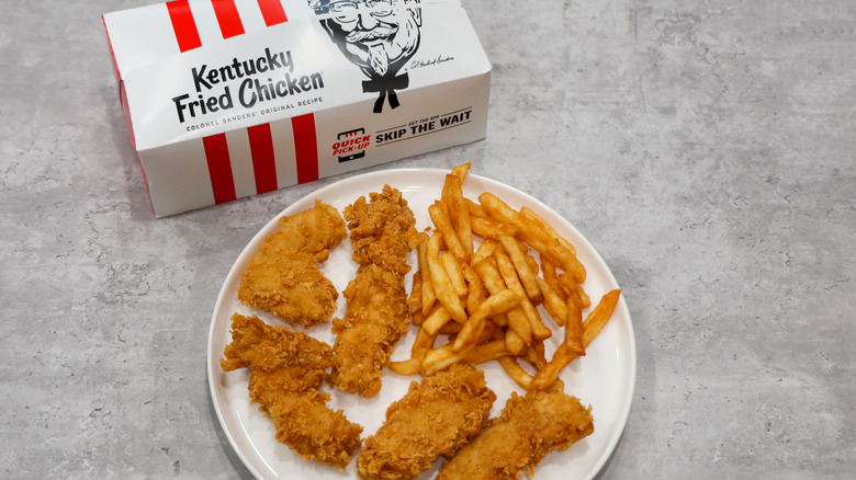 KFC fried chicken tenders and french fries on a plate with KFC box