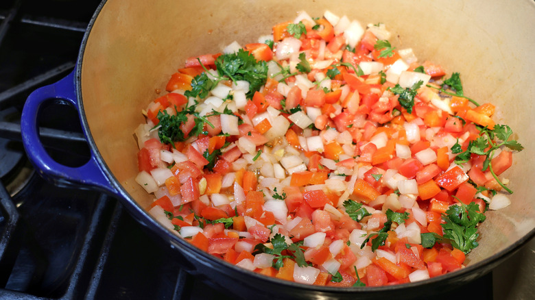 large pot with diced onion, tomato and cilantro in it