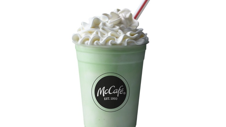 Green milkshake with whipped cream and cherry