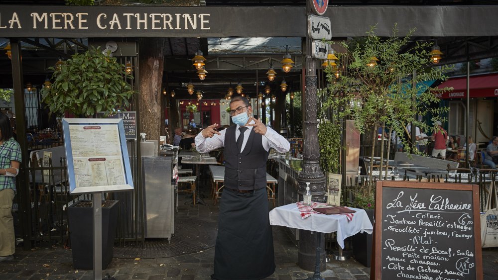 Waiter standing outside restaurant in France