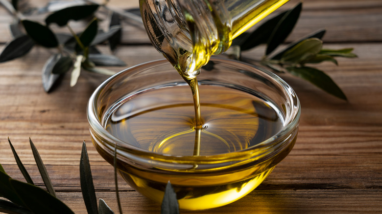 Greek olive oil being poured into a ramekin 