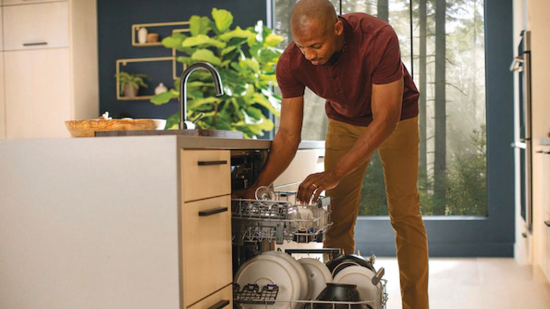 Man loading an Electrolux dishwasher