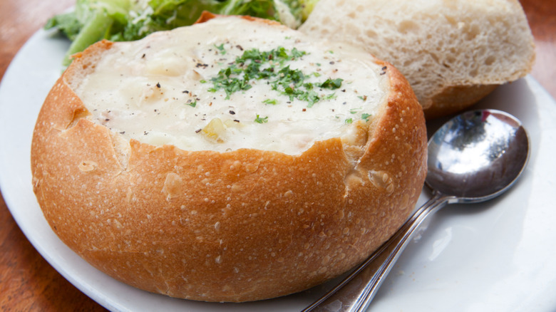 Bread bowl of clam chowder with spoon