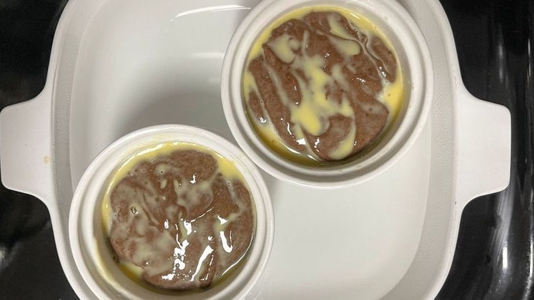 Unbaked chocoflans in ramekins inside of water bath