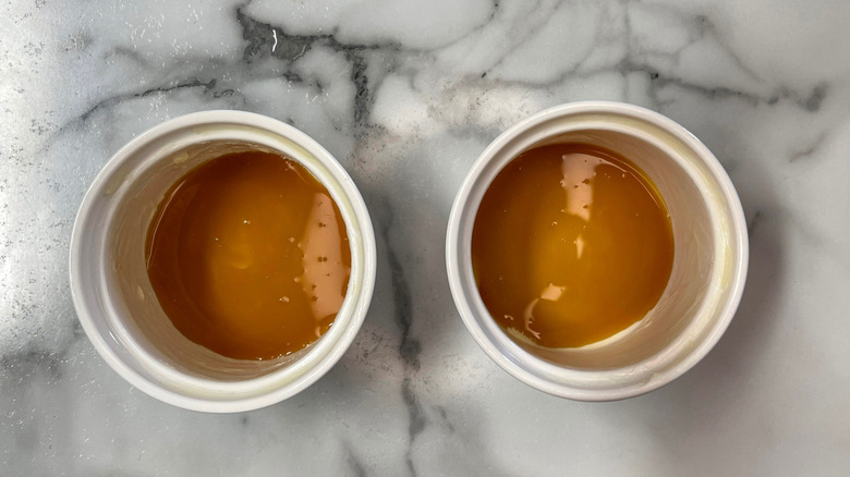 Buttered ramekins with caramel sauce at the bottom