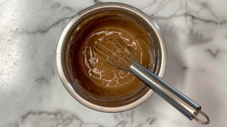 Chocolate cake mix in bowl with whisk