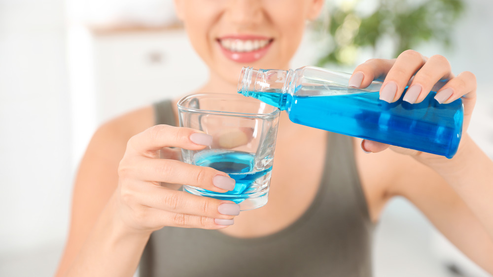 Pouring mouthwash into a glass