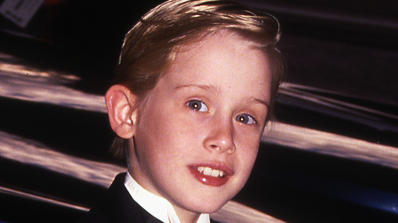Young Macaulay Culkin smiles in suit