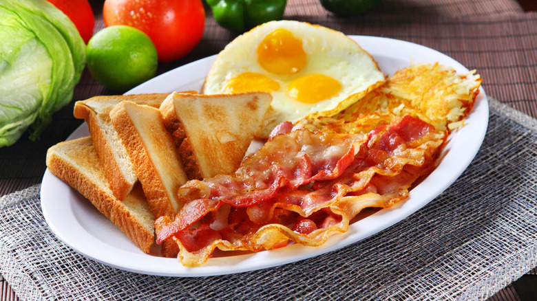 eggs toast bacon and hashbrowns on plate