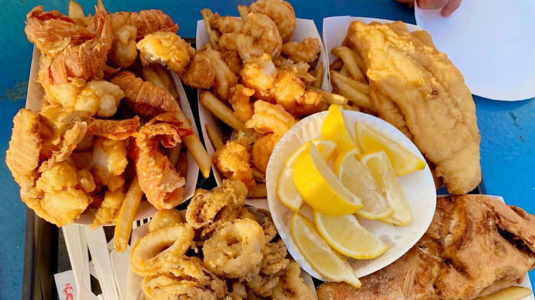 Cartons of fried seafood with plate of lemon wedges