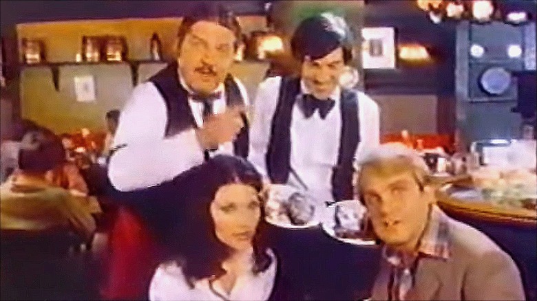Shot from a Beefsteak Charlie's commercial; waiters serving steak to patrons
