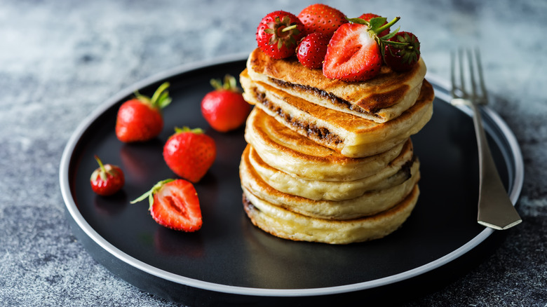 Stack of pancakes with Nutella and strawberries