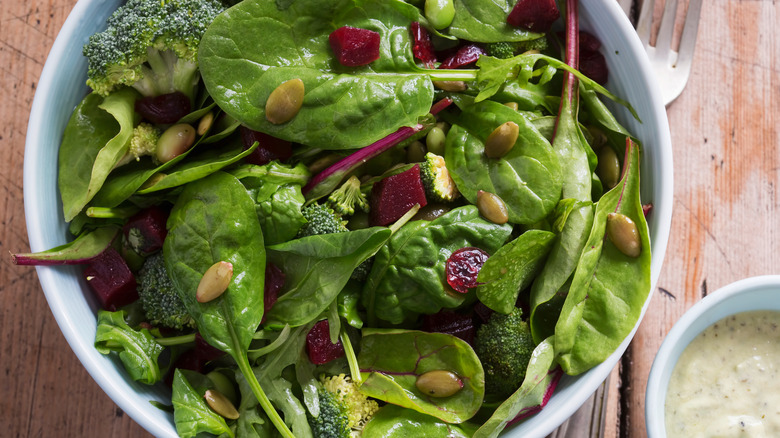 Spinach salad in a white bowl.