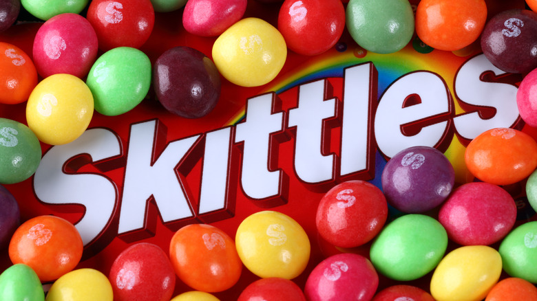Skittles logo surrounded by Skittles candies