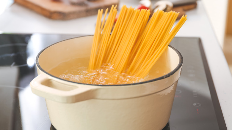 spaghetti noodles in boiling pot on the stove
