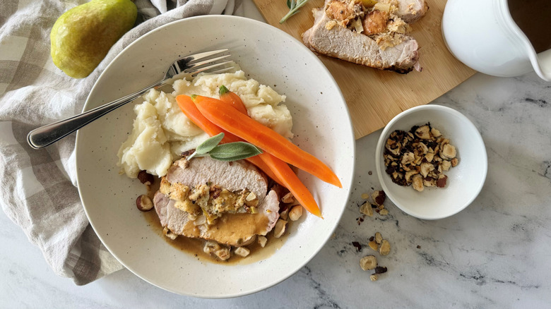 Stuffed pork loin with mashed potatoes and carrots on plate