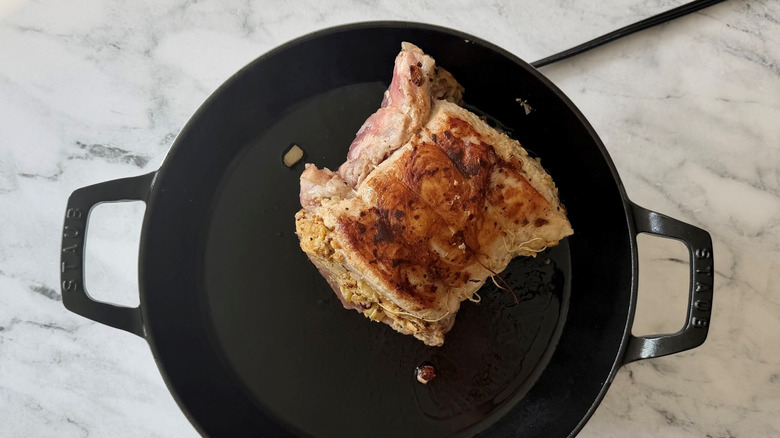 Seared stuffed pork loin in skillet