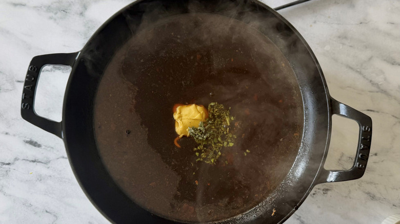 Pan sauce with minced sage and Dijon mustard in skillet