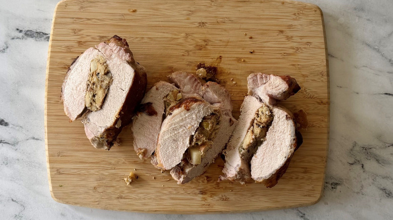 Sliced stuffed pork loin on wooden board