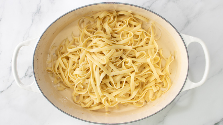 fettuccine in dutch oven with cheesy cream sauce