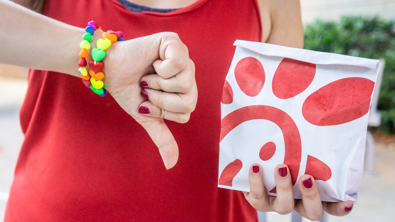 Customer giving thumbs down while holding Chick-fil-A bag