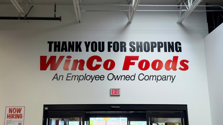 A white wall inside a warehouse supermarket with black and red text