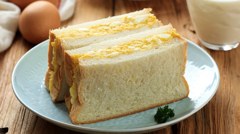 Egg salad sandwich on blue plate.