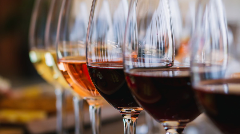 Row of wine glasses with a different wine variety in each.