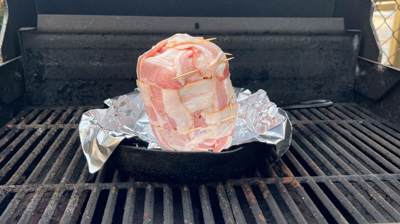 Bacon-wrapped pineapple in cast iron skillet on grill