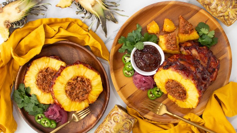 Pork-stuffed pineapple slices on plate next to pork-stuffed pineapple with various toppings