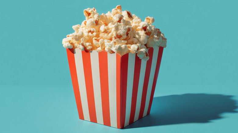 A red and white vertically striped bucket full of popcorn