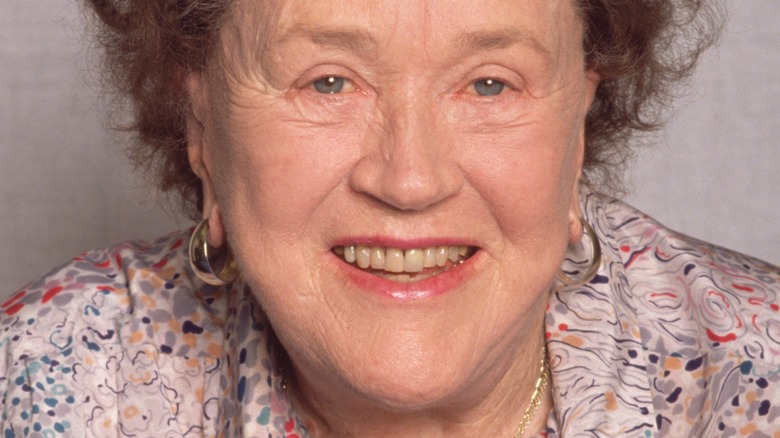 Julia Child with wide smile and gold hoop earrings