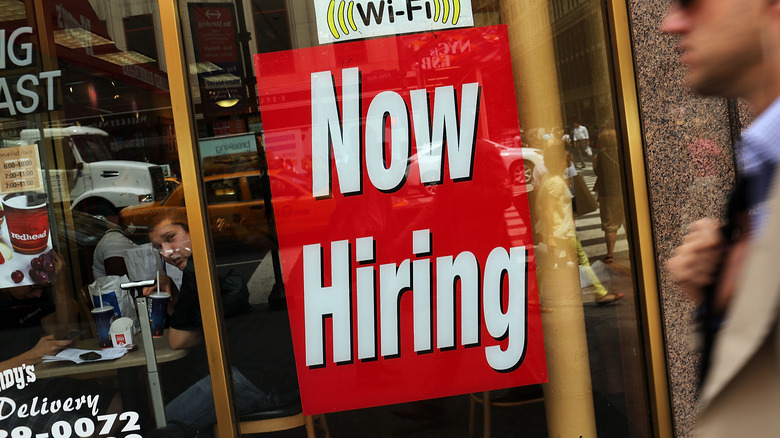 "Now hiring" sign at restaurant