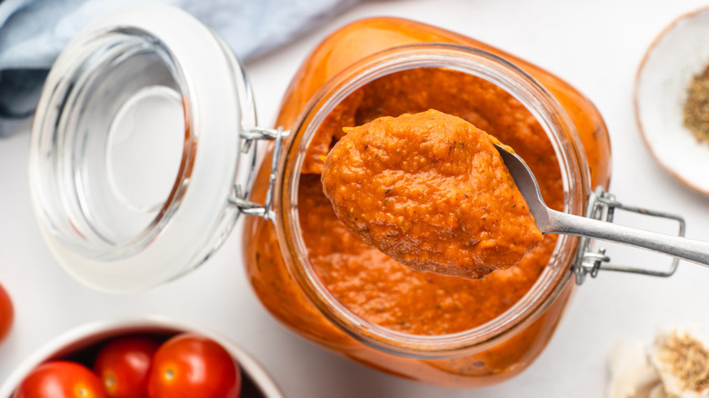 Spooning marinara sauce out of glass jar