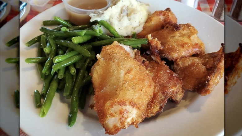 Plate of fried chicken with potatoes and green beans