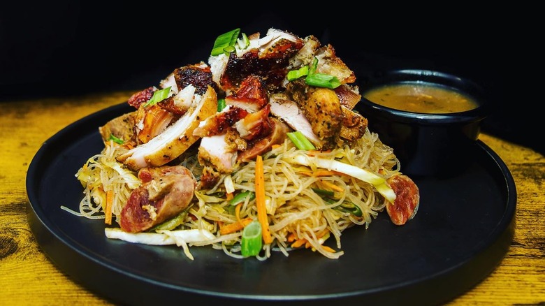 Pancit on black plate with sauce