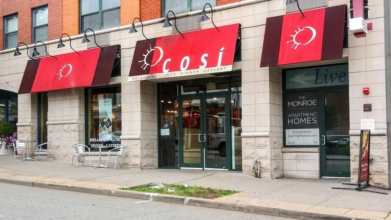The exterior of a Così sandwich cafe with red awnings in Morristown, New Jersey