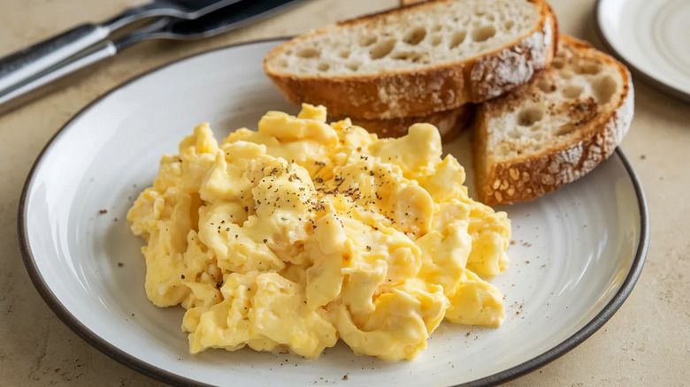 Plate with seasoned scrambled eggs and toast.
