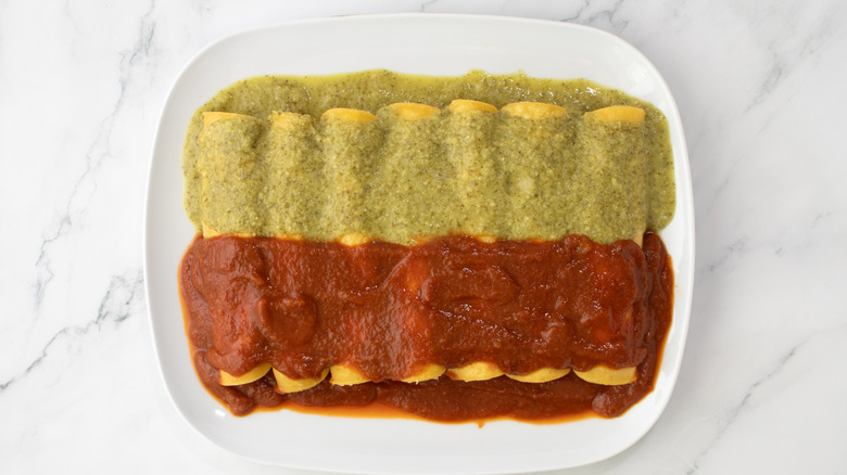rolled tortillas topped with green and red sauce