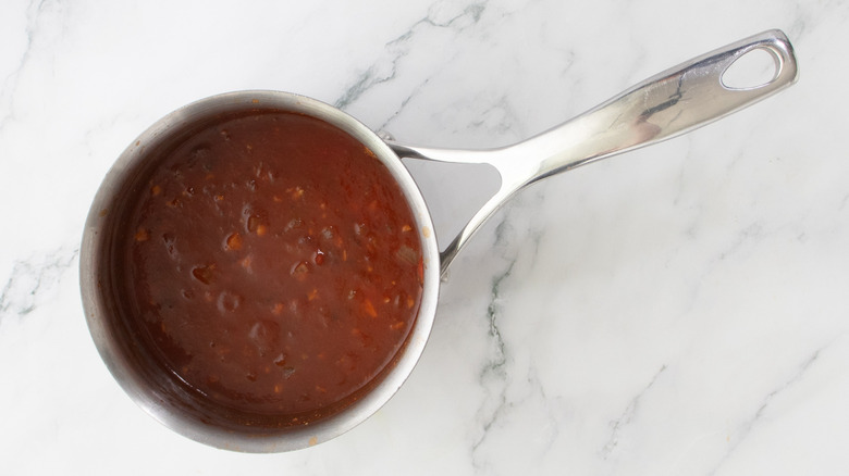 red sauce ingredients simmering in saucepan