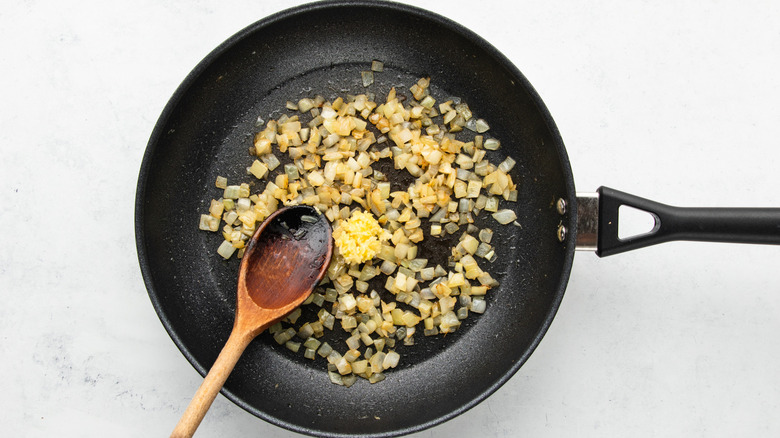 Onion and garlic sauteing in frying pan