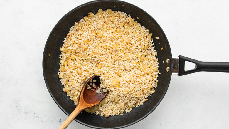 Arborio rice and diced onion in frying pan
