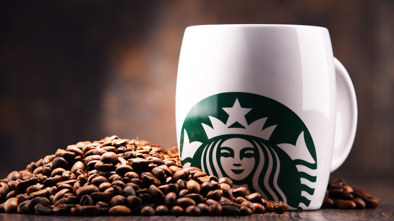 Starbucks mug next to coffee beans