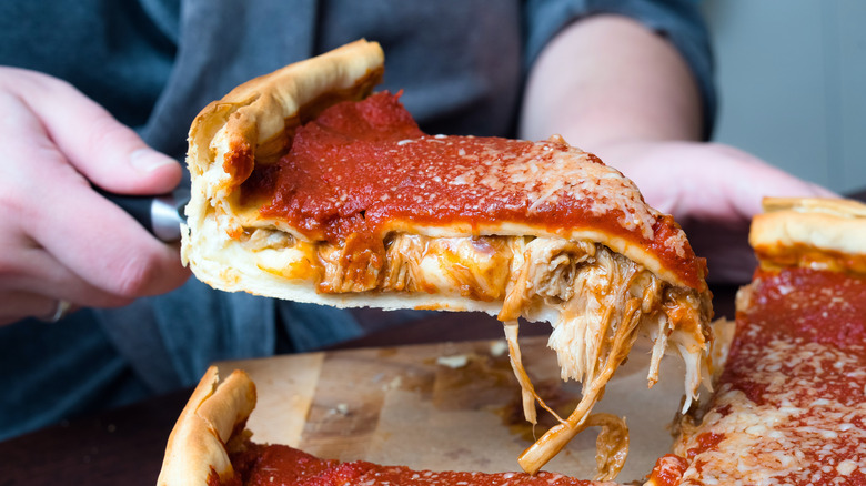 Cutting a slice of deep dish pizza