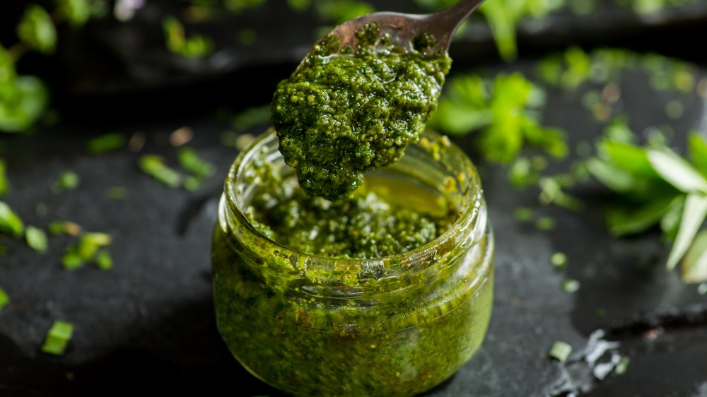 jar and spoon of pesto sauce