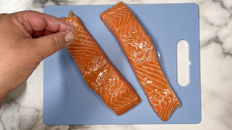 sprinkling salt on salmon