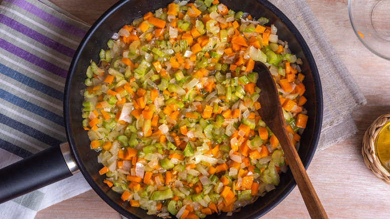 Soffritto in a pan with wooden spoon