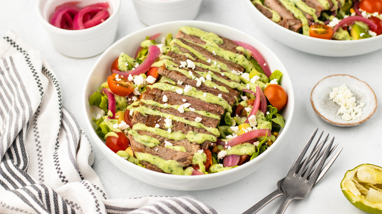Steak taco salad with avocado dressing and crumbled cotija cheese