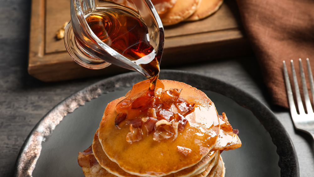 Syrup being poured on pancakes